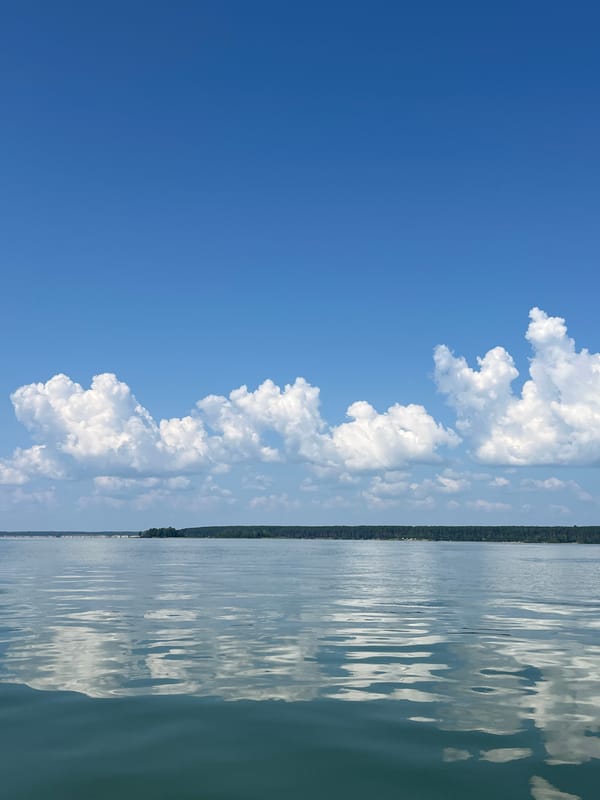 Fishing a still lake under blue summer skies in Borovoe
