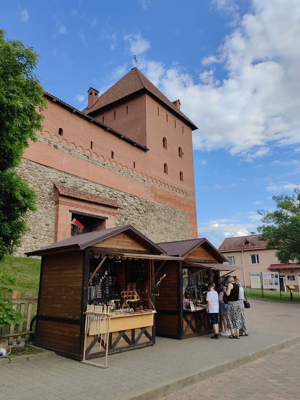Visitors and vendors gather outside an old brick castle