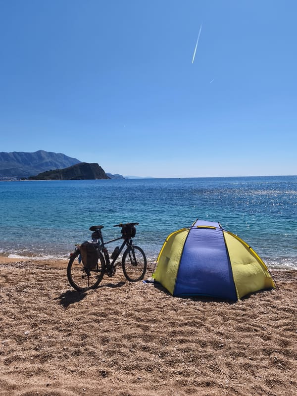 Coastal camping documented at rocky beach with caves