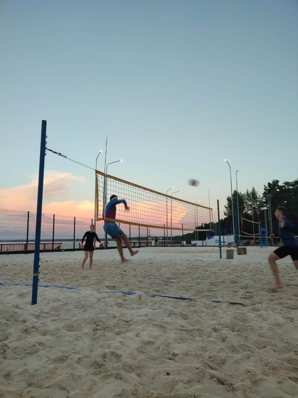 Beach volleyball at dusk by the water
