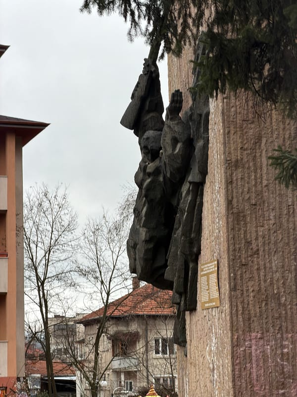 Stone sculpture memorial observed on brick wall in Velingrad