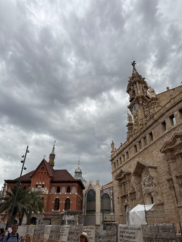 Crowds move through València's ornate pedestrian boulevard on a cloudy day