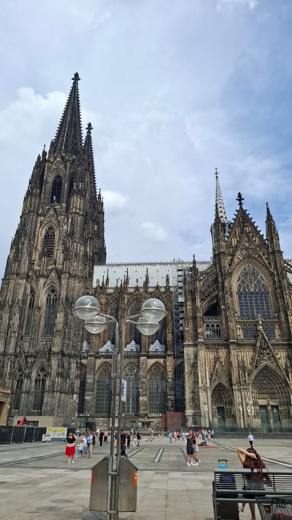 Morning at Cologne Cathedral plaza, flowers, chalk art, and Gothic spires