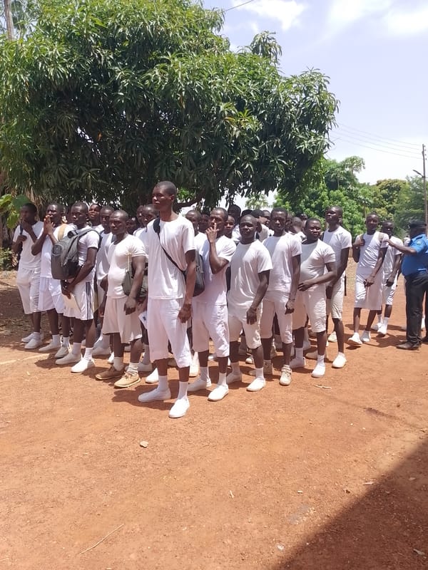 Young men in white uniforms march in formation