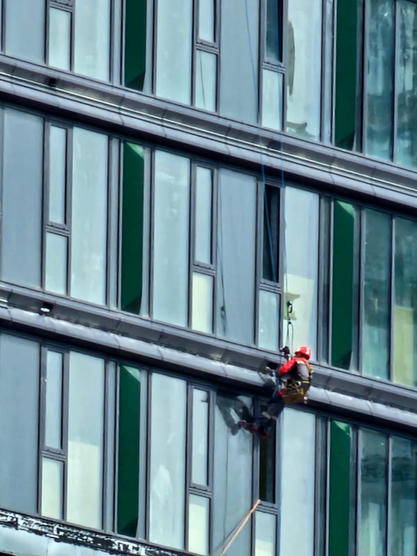 Rope-suspended workers service a glass skyscraper facade in Moscow