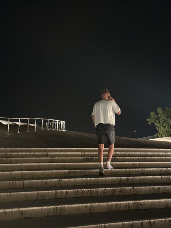 Lisbon at night: bridge lights, river reflections, and a lit staircase