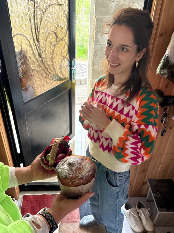 Woman receives wrapped bread loaf indoors in Chakvi