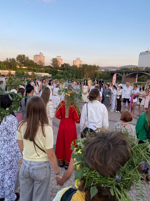 Circle dancing and flower crowns at an outdoor folk celebration