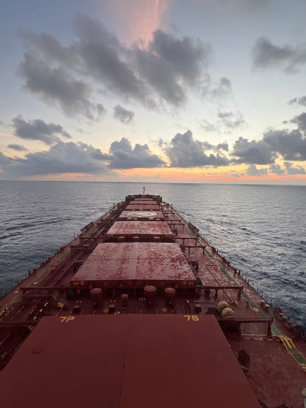 Cargo ship at sea under a stormy South China Sea sunset
