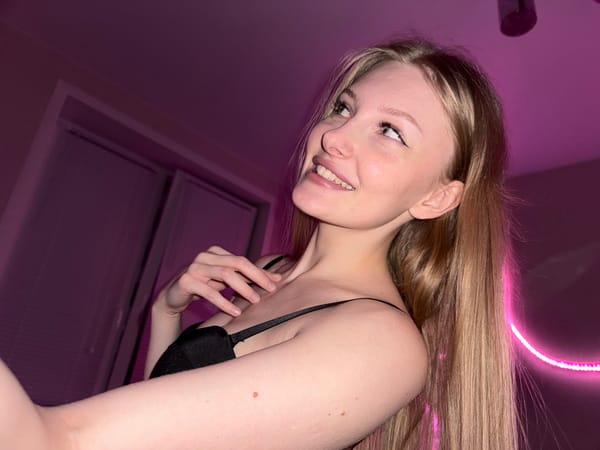 Woman takes selfies in pink-lit room in Perm