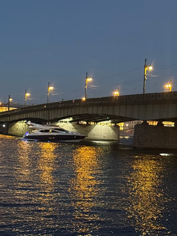 White yacht cruises the Neva River on a St. Petersburg summer night