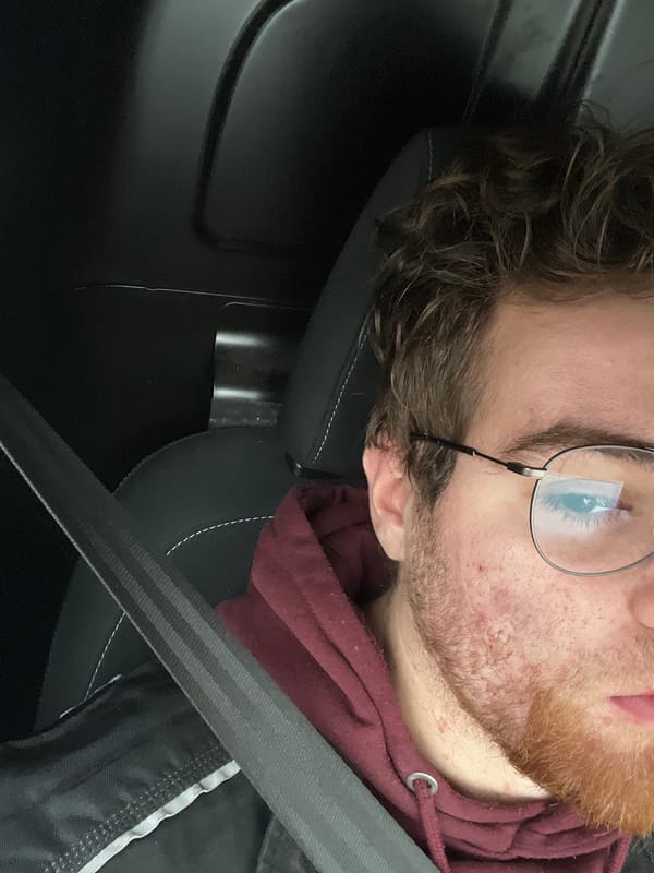 Man in glasses and maroon hoodie spotted in car