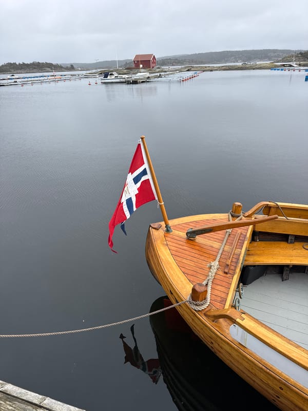 Norwegian-flagged sailboat docked in Strömstad under gray skies