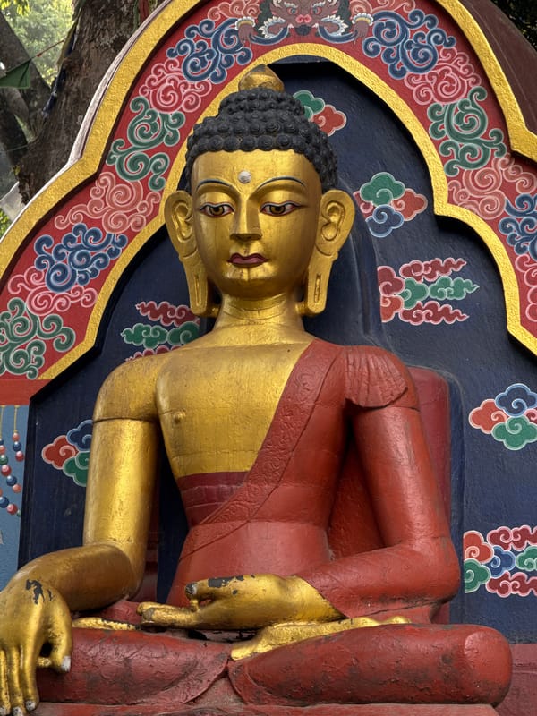 Buddhist temple visit documented in Kathmandu with statue, prayer flags