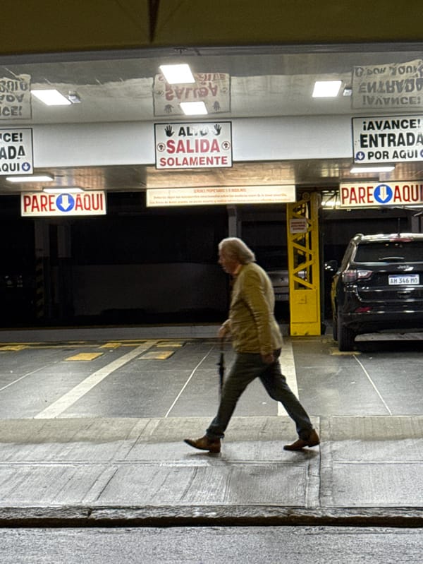 Elderly man walks toward wall in Buenos Aires parking garage