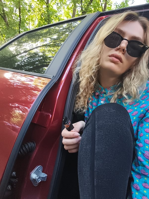 Person in alien shirt sits in red car, Izhevsk