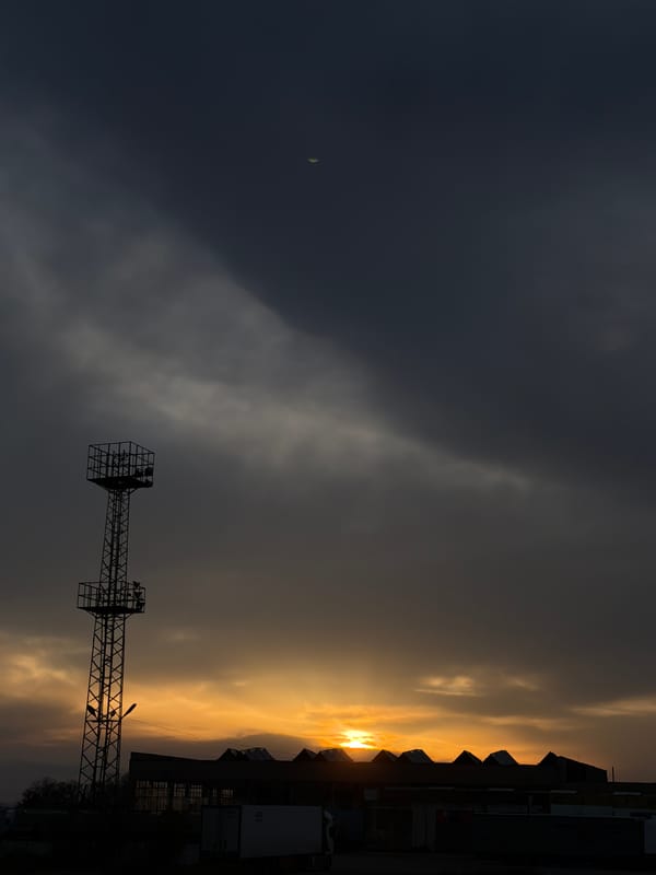 Sunset silhouettes transmission tower in Chirpan, Bulgaria