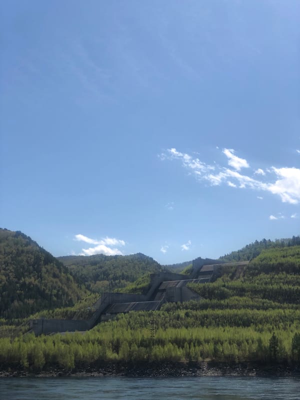 Hillside concrete structure observed amid vegetation near Cheremushki water