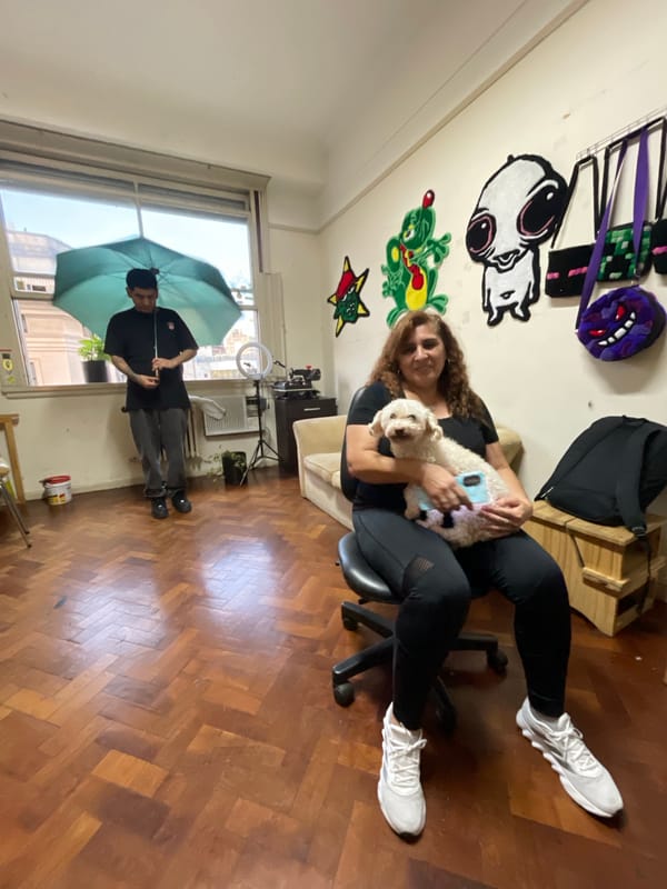 Indoor scene captured with woman, dog, and umbrella-holding man