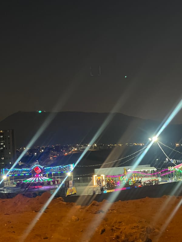 Woman observed near nighttime carnival with illuminated rides