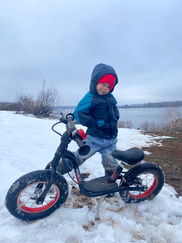 Child with balance bike spotted in snow in Ольховка