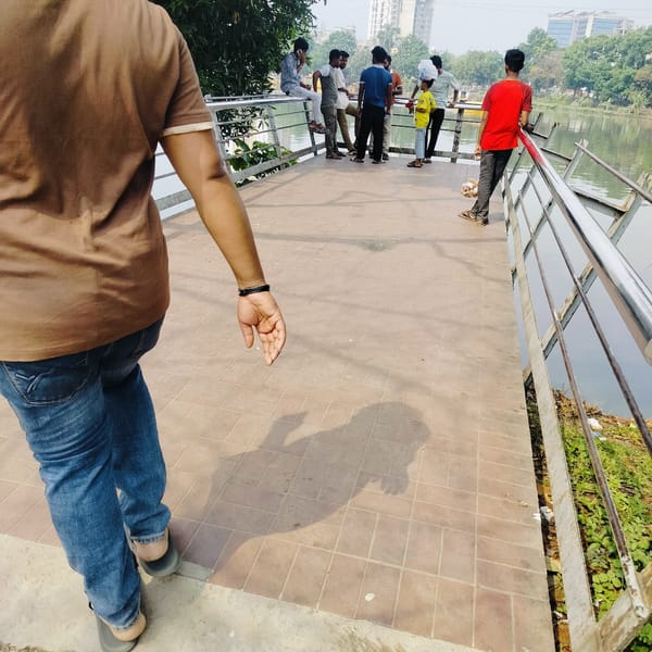 Pedestrians gather on Dhaka walkway during daytime