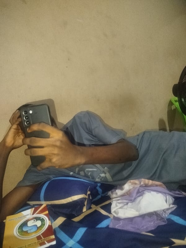 Chilling indoors with a phone and a computer book nearby