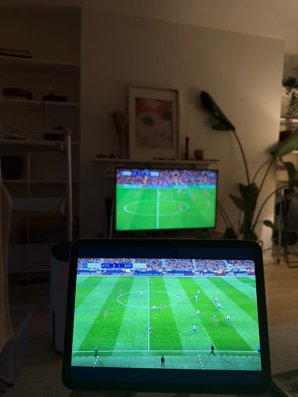 Person watches football match on multiple screens in London