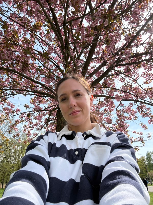 Woman enjoys spring blossoms under flowering tree in Riga