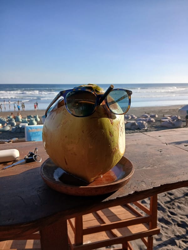 Lazy morning at a Bali beach bar with surf and coconuts