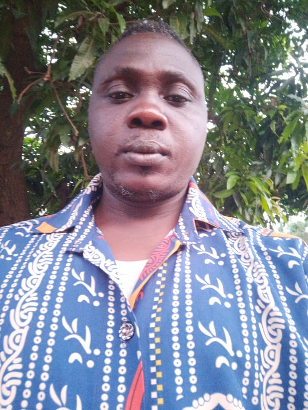 Man in blue patterned shirt observed outdoors in Akwanga
