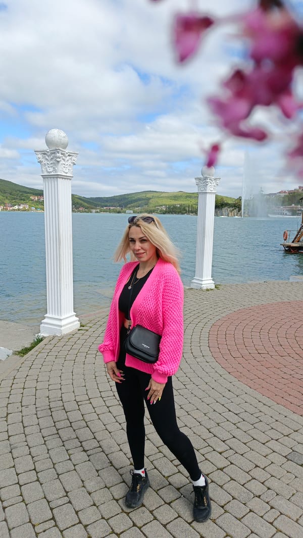 Woman in pink cardigan observed on waterfront promenade in Russia