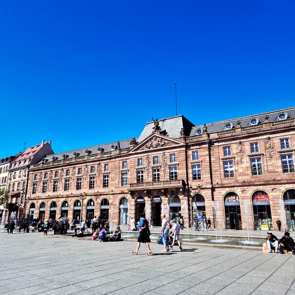 Afternoon gathering captured in Strasbourg public square under clear skies