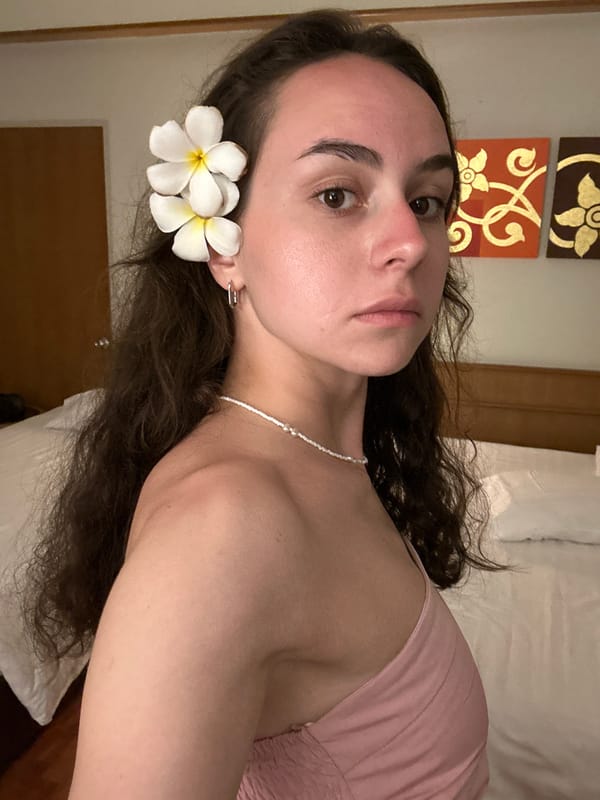 Woman poses with plumeria flowers in Pattaya hotel room