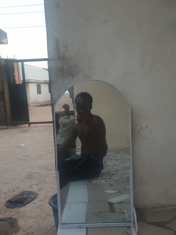 Man takes outdoor mirror selfies in Lokoja courtyard