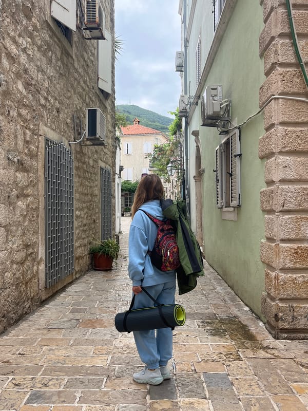 Woman with exercise gear walks through Budva's historic streets