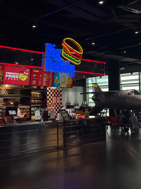 Restaurant interior with illuminated food signage documented in Schwechat