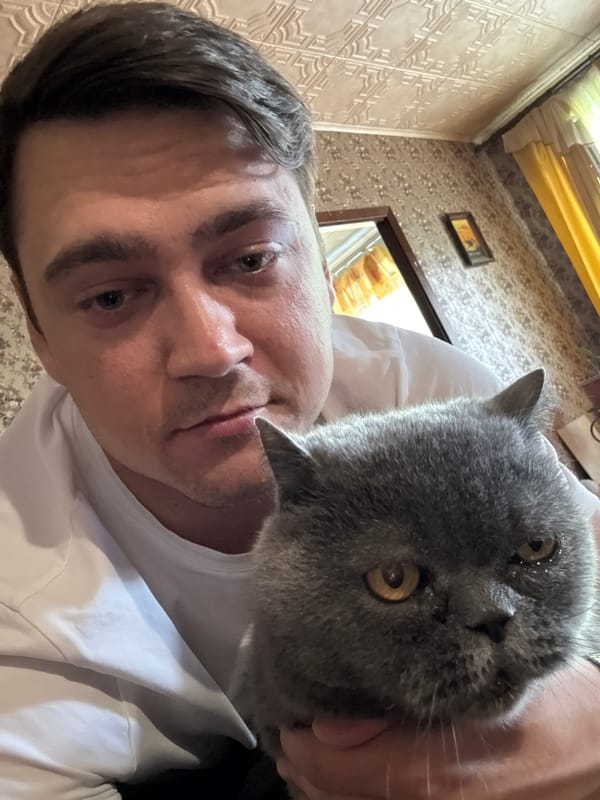 Man spends quiet afternoon with grey cat in Minsk home