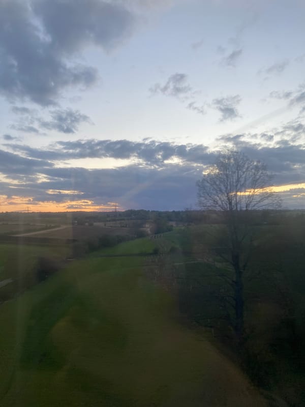 Sunset observed through window in London amid cloudy skies
