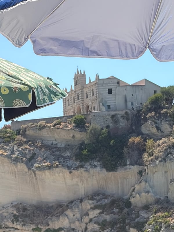 Sunny afternoon on Tropea's beach below the clifftop church