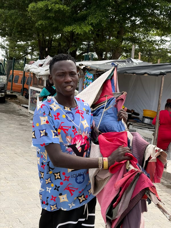 Man carries colorful cloth bundle on Igboefon street
