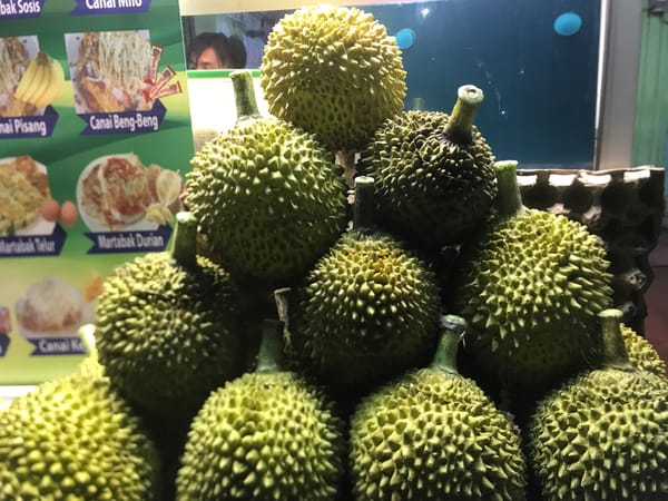 Street vendors sell durian and cooked foods in Lhokseumawe