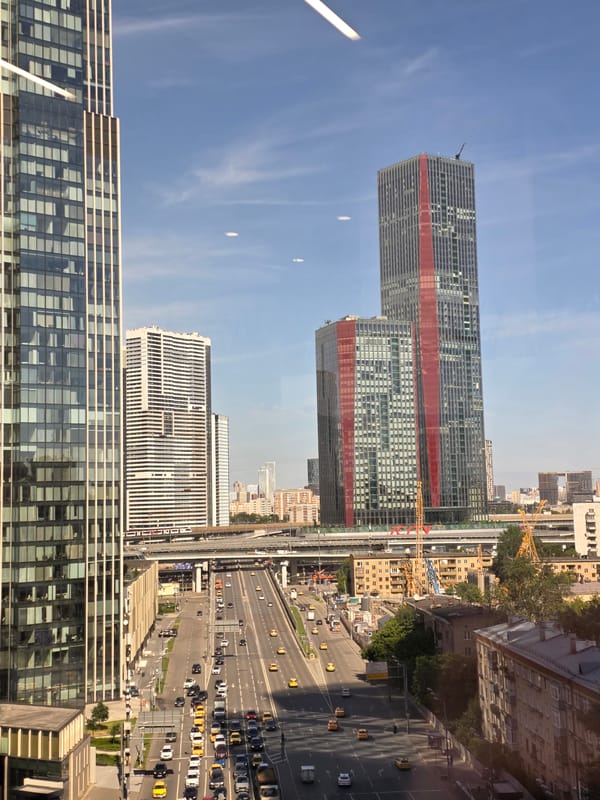 Glass-fronted building anchors a busy city scene from above