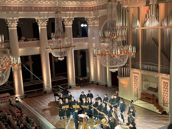 Orchestra and choir perform in grand concert hall
