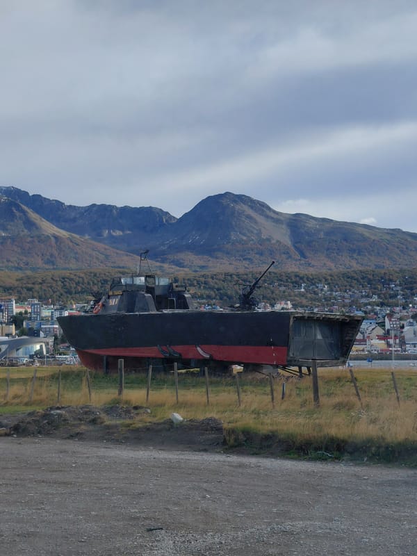 Rusted decommissioned ship displayed on land in Ushuaia