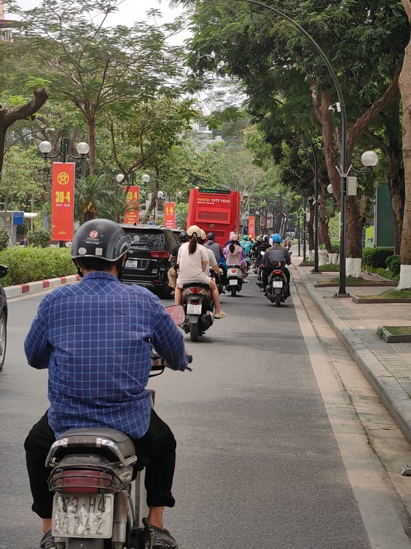 Morning motorbike traffic flows through Hanoi streets