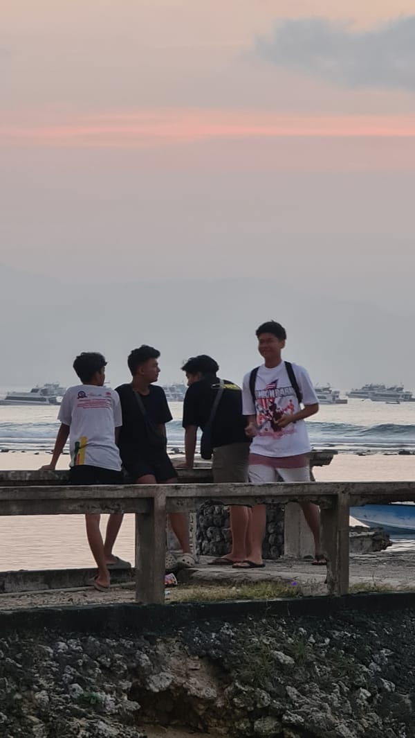 Dusk at Denpasar beach — shoreline, water, and walkway at sunset