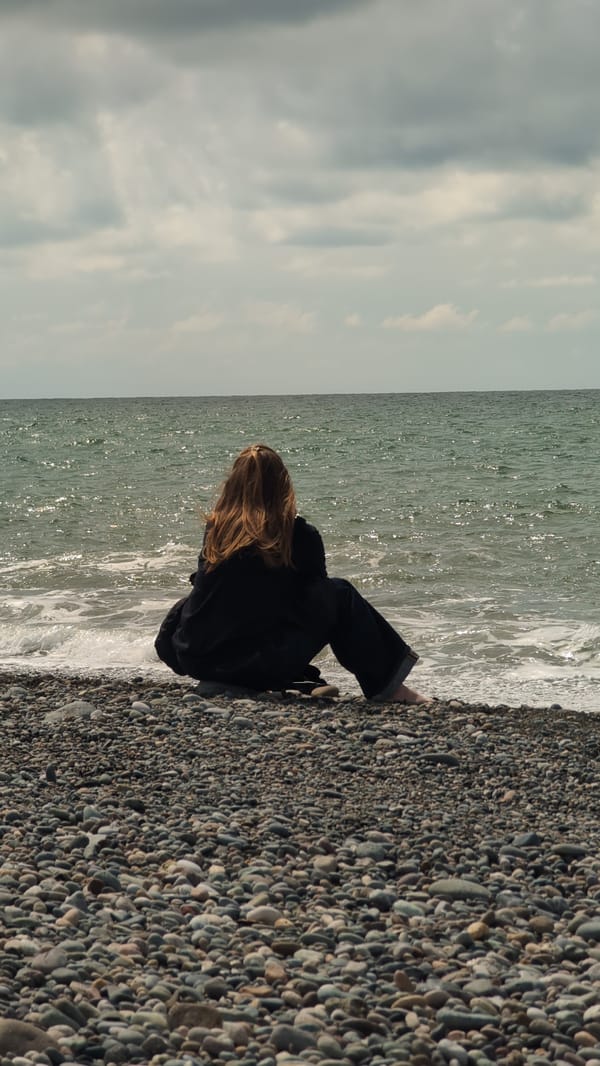 Person spends quiet moments on Kobuleti beach using smartphone