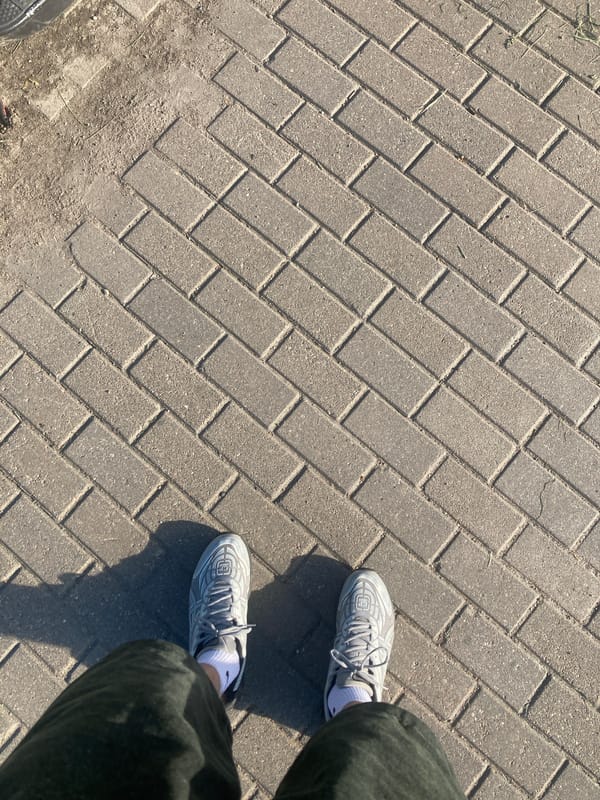 Person photographed standing on herringbone brick pavement in Minsk
