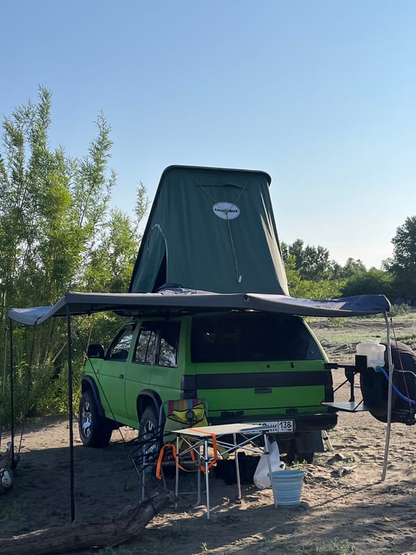 Overland camp set up on a sandy Russian riverbank